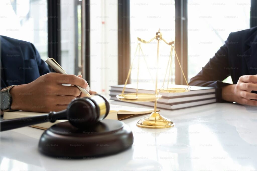 Legal consultation scene with scales of justice, gavel, and two professionals discussing ADA mediation and disability law